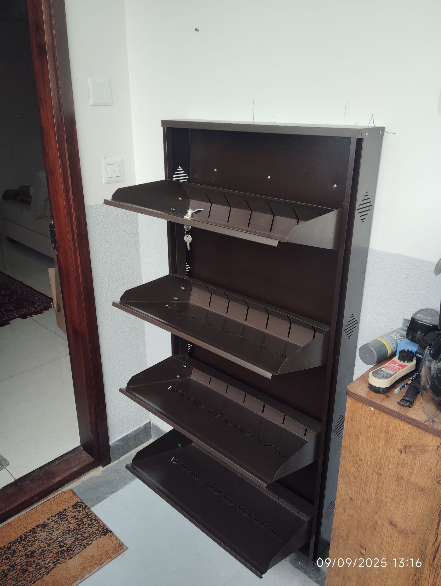 Brown wall-mounted flip-out shoe rack installed at apartment entryway